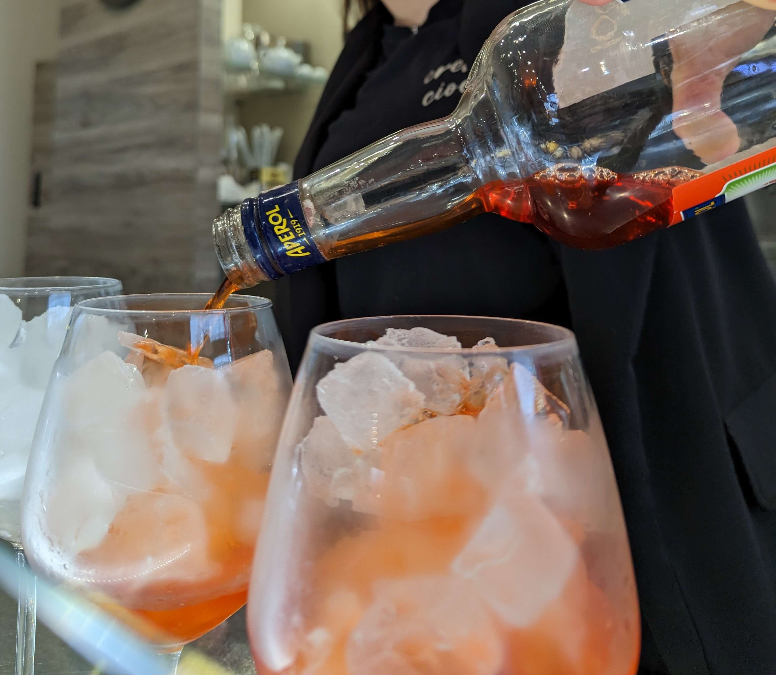Calice di Aperol spritz mentre viene versato l'aperol